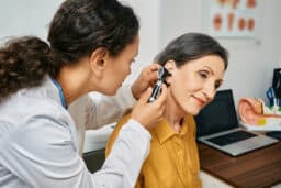 Doctor looks inside woman's ear