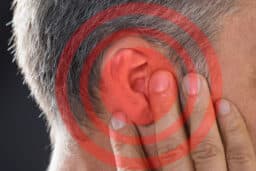 Red circles around a man's ear, tinnitus concept