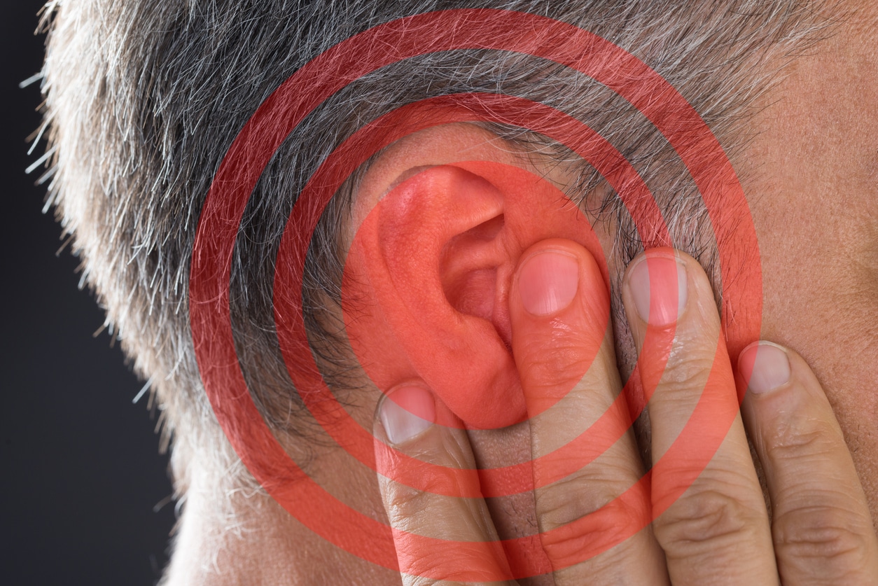 Red circles around a man's ear, tinnitus concept.