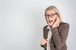 Woman with tinnitus grimacing and holding her ear