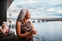 Confident senior woman at a restaurant looking out at the water