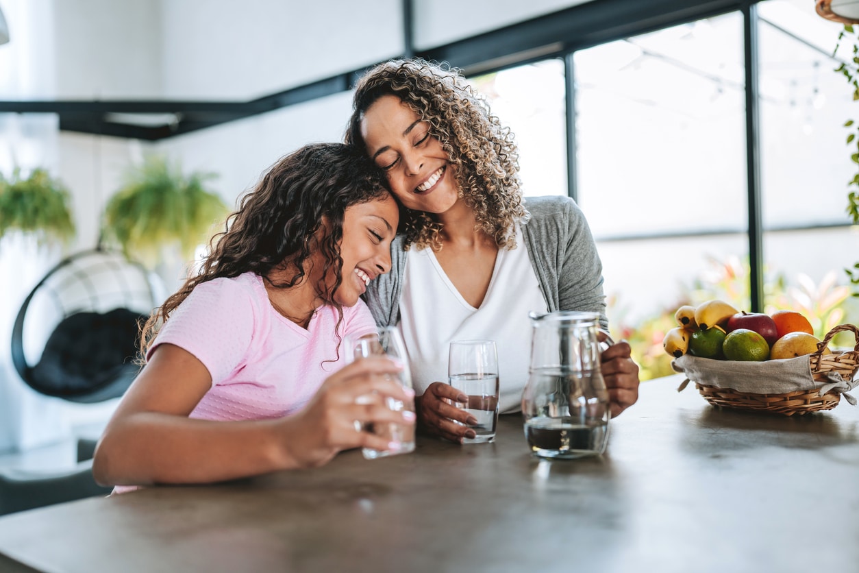 Mother and daughter drinking water together.
