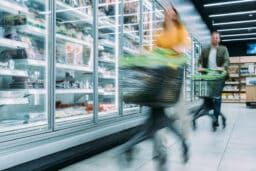 Busy customers pushing shopping carts at the supermarket.