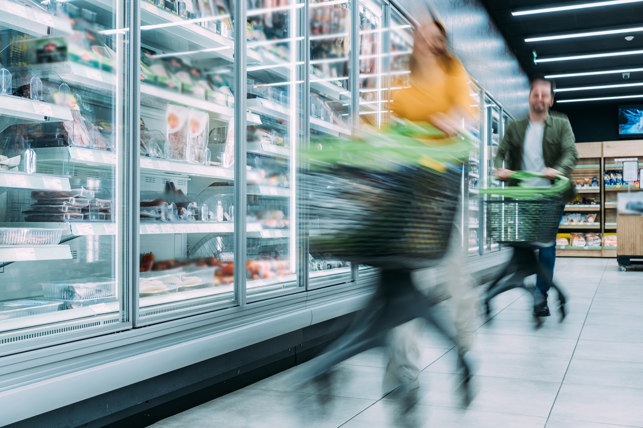 Busy customers pushing shopping carts at the supermarket.