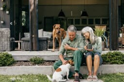 A couple in their 60s enjoys a slow morning, sipping coffee in the fresh air.