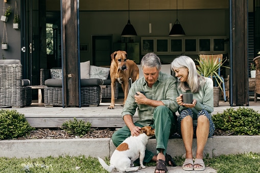 A couple in their 60s enjoys a slow morning, sipping coffee in the fresh air.