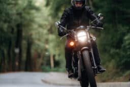 Man in leather clothes on motorcycle is on the road.